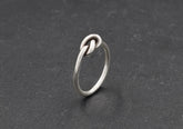 Minimalist knot ring from Hill to Street over black background